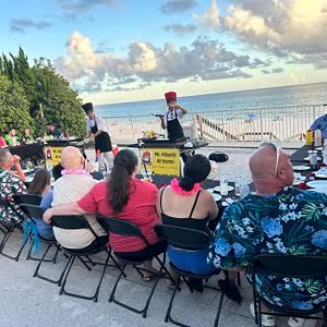 Guests at long tables for a beachfront hibachi dinner in Destin