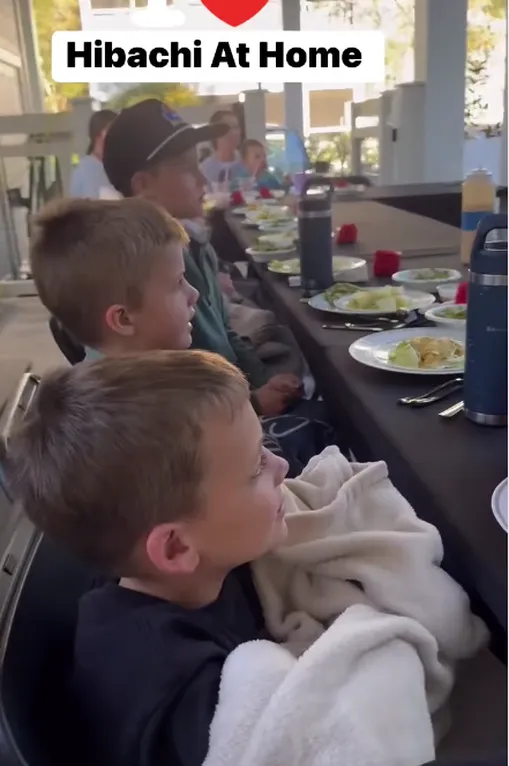 Kids at a long table watching a hibachi chef