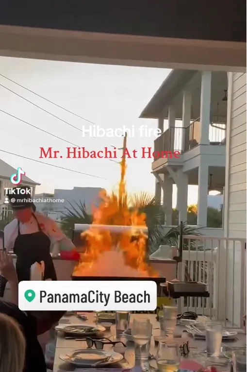 Tall flames from a hibachi grill on a deck in Panama City Beach