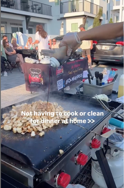 Fried rice cooking on a mobile hibachi grill in a driveway