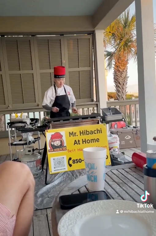 Hibachi chef at a mobile grill on a covered porch