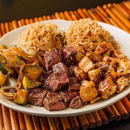 Plate of hibachi steak and chicken with fried rice and vegetables