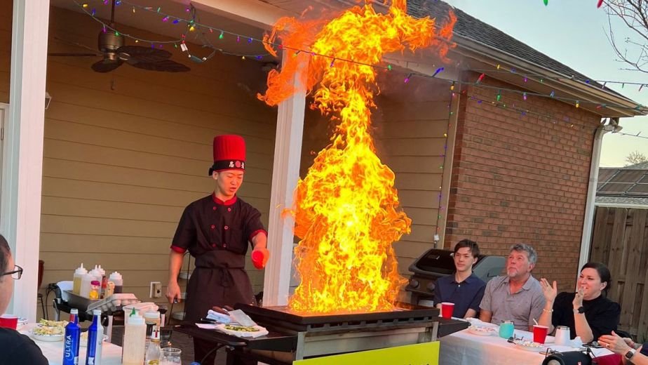 Hibachi chef with a tall flame on a covered patio