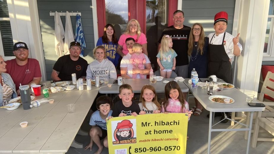 Large family group photo with the hibachi chef on a porch