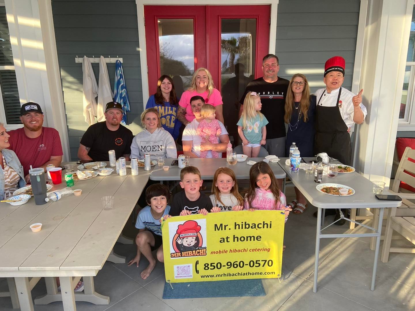 Large family group photo with the hibachi chef on a porch