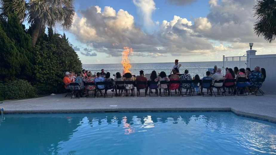 Guests seated by a pool at sunset for a hibachi dinner